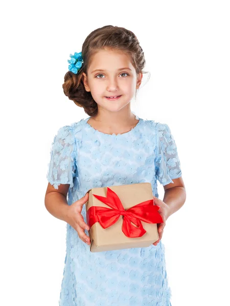 Niña en un vestido elegante y peinado sosteniendo un regalo — Foto de Stock