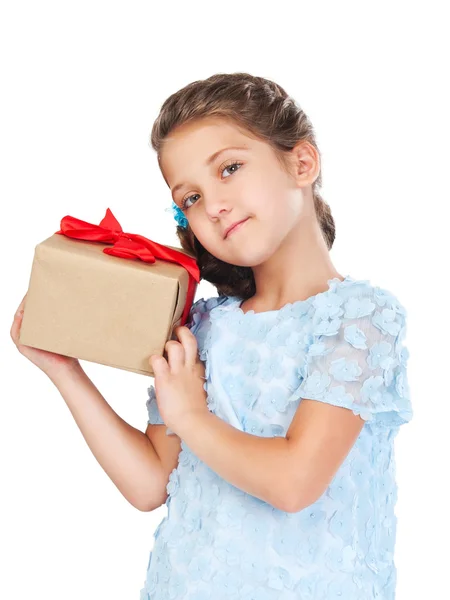 Klein meisje in een slimme jurk en kapsel bedrijf van een gift — Stockfoto