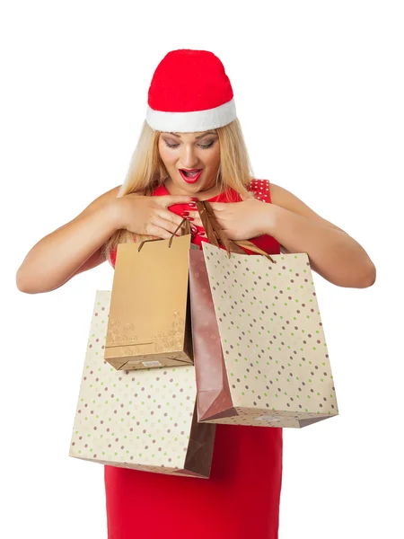 Bella ragazza in cappello Babbo Natale helper guardando borse della spesa — Foto Stock