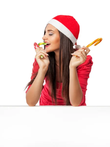 Mooi meisje in een rode jurk eten riet van het suikergoed — Stockfoto