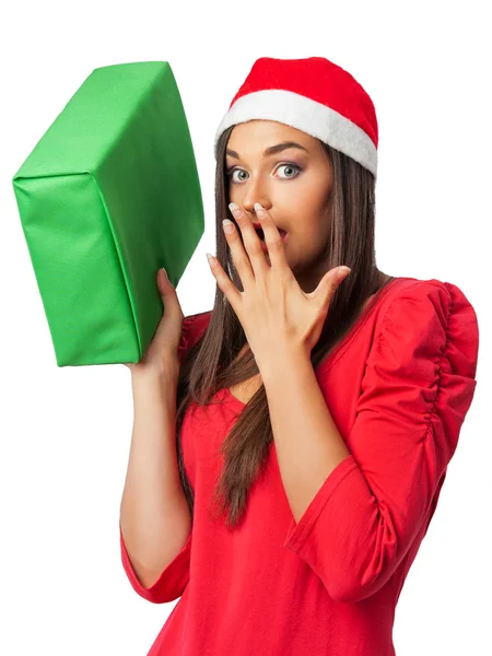 Menina surpresa em um traje de Natal está segurando um presente verde Imagem De Stock