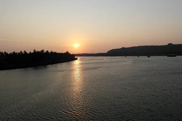 平面なフラットの川の水に沈む夕日 — ストック写真