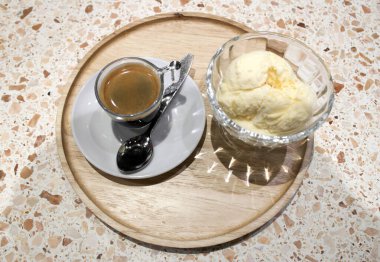 Yuvarlak tabakta kahve fincanı ve dondurma vazosu