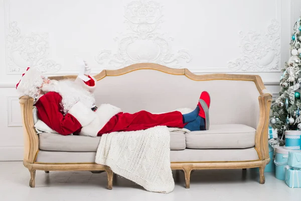 Babbo Natale utilizzando il telefono cellulare a casa durante il periodo natalizio — Foto Stock