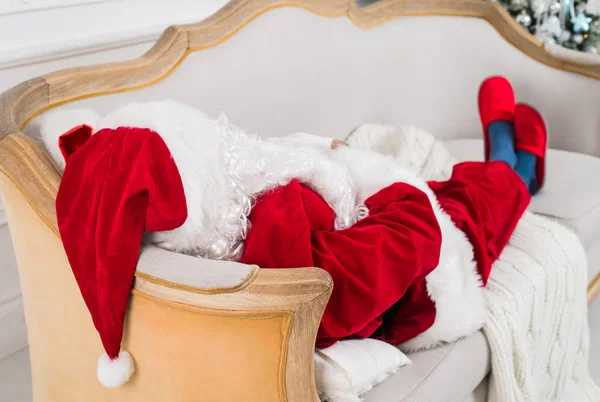 Babbo Natale che riposa su un divano a casa . — Foto Stock