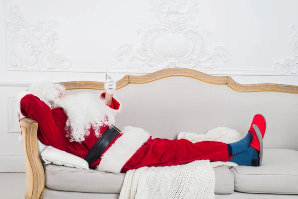Babbo Natale che riposa su un divano a casa . — Foto Stock