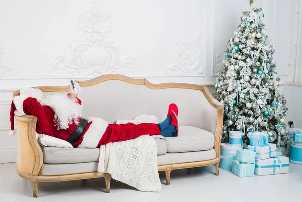 Santa Claus descansando en un sofá en casa . —  Fotos de Stock