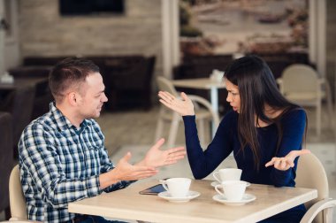 Genç bir çift bir kafede savunarak. Shes canıma tak etti, erkek özür diliyor. İlişki sorunları.