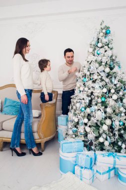 Neşeli evli çift ile onların çocuk Noel kutluyor. Çam ağacı süsleme ve gülüyor