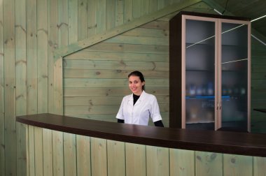 Receptrion kadın gülümsüyor ve spa ya da modern klinik sanal ziyaretçi ağırlıyor. Anlaşma senin elinde kağıtlarla.