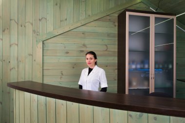 Receptrion kadın gülümsüyor ve spa ya da modern klinik sanal ziyaretçi ağırlıyor. Anlaşma senin elinde kağıtlarla.