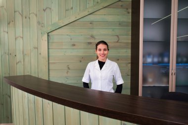 Receptrion kadın gülümsüyor ve spa ya da modern klinik sanal ziyaretçi ağırlıyor. Anlaşma senin elinde kağıtlarla.