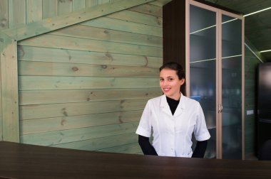 Receptrion kadın gülümsüyor ve spa ya da modern klinik sanal ziyaretçi ağırlıyor. Anlaşma senin elinde kağıtlarla.