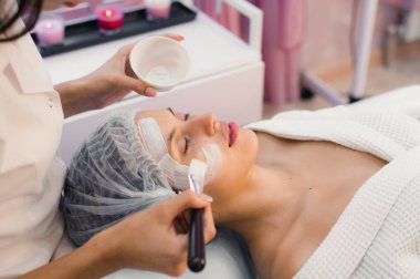 Spa yordamı yüzünde sahip genç güzel kadın