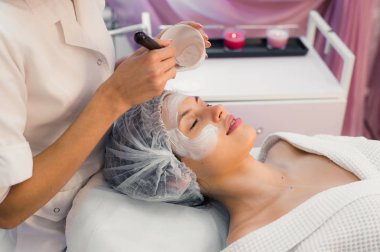 Spa yordamı yüzünde sahip genç güzel kadın