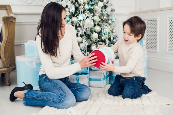 Vrouw en jongen controle kerstcadeautjes — Stockfoto