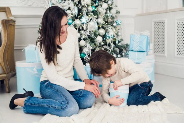 Femme et garçon vérifiant les cadeaux de Noël — Photo