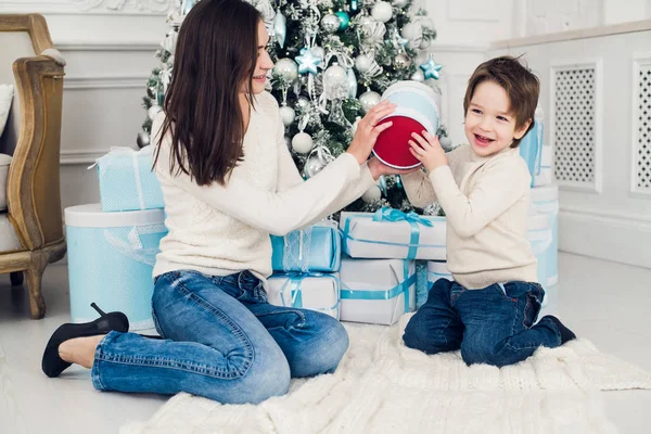 Vrouw en jongen controle kerstcadeautjes — Stockfoto