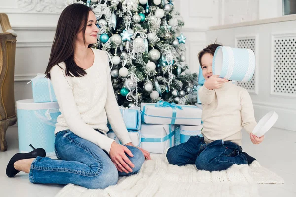 Vrouw en jongen controle kerstcadeautjes — Stockfoto