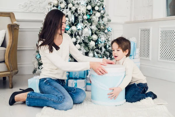 Vrouw en jongen controle kerstcadeautjes — Stockfoto