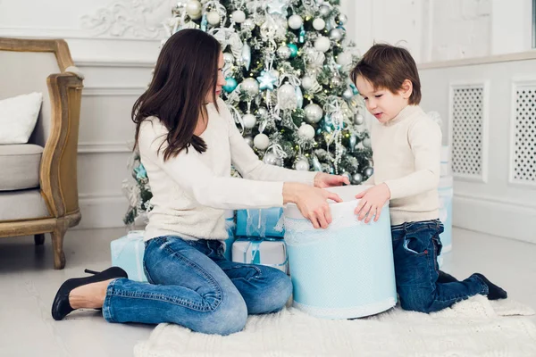 Femme et garçon vérifiant les cadeaux de Noël — Photo