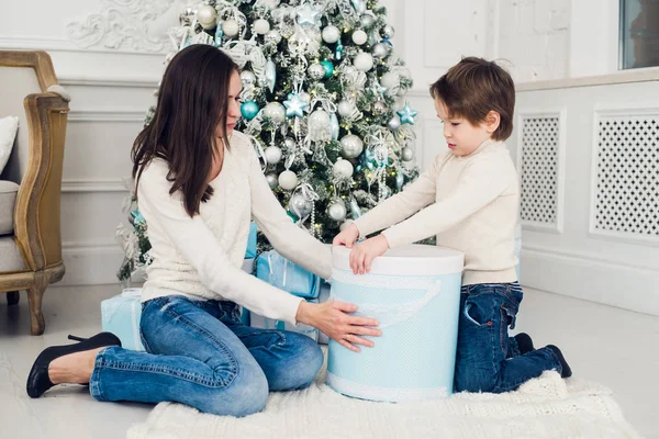 Femme et garçon vérifiant les cadeaux de Noël — Photo