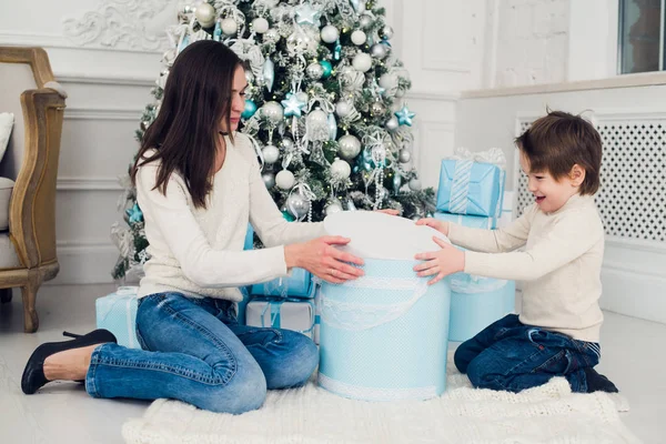 Vrouw en jongen controleren kerstcadeautjes thuis — Stockfoto