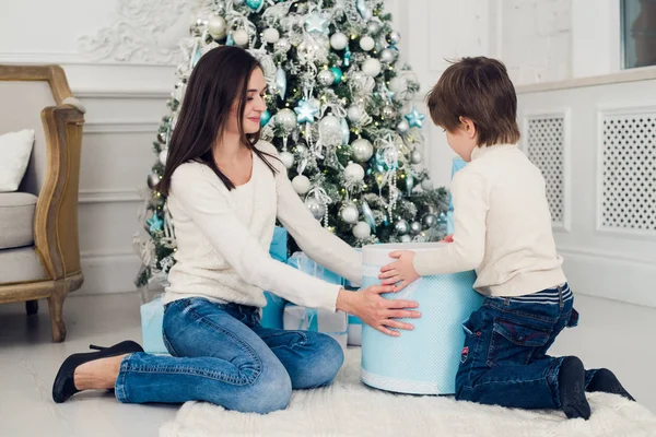 Femme et garçon vérifiant les cadeaux de Noël à la maison — Photo