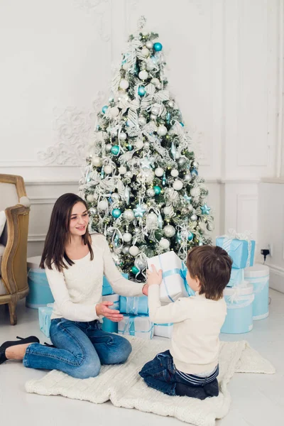 Mujer y niño revisando regalos de Navidad en casa —  Fotos de Stock