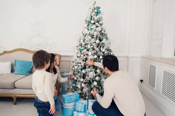 Familia decorando un árbol de Navidad con boubles en el salón —  Fotos de Stock