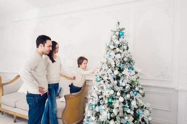 Família decorar uma árvore de Natal com bolhas na sala de estar — Fotografia de Stock