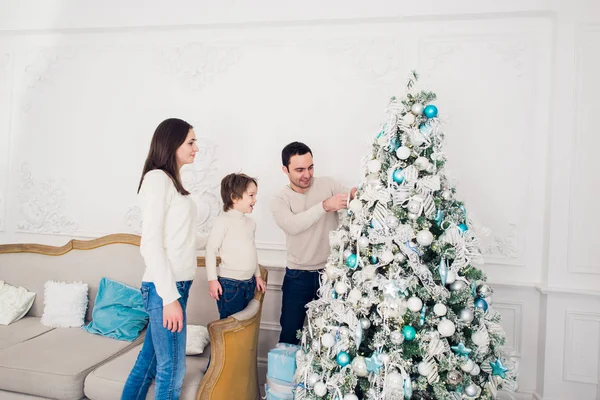 Familia decorando un árbol de Navidad con boubles en el salón —  Fotos de Stock