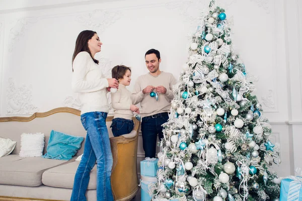 Familia decorando un árbol de Navidad con boubles en el salón —  Fotos de Stock