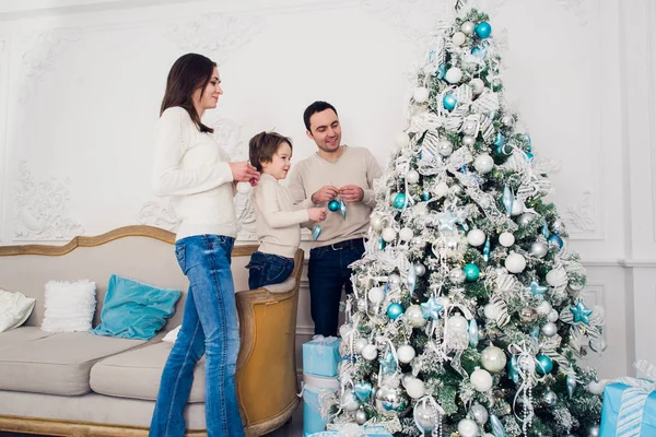 Familia decorando un árbol de Navidad con boubles en el salón —  Fotos de Stock