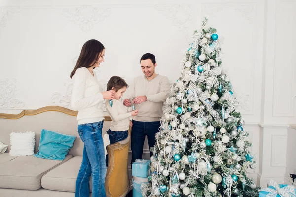 Familia decorando un árbol de Navidad con boubles en el salón —  Fotos de Stock