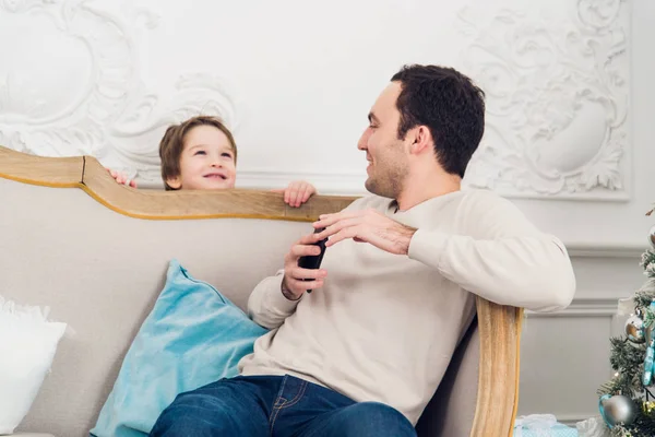 Portrait of little boy behind sofa at home playing with father Hide and Seek — Stock Photo, Image