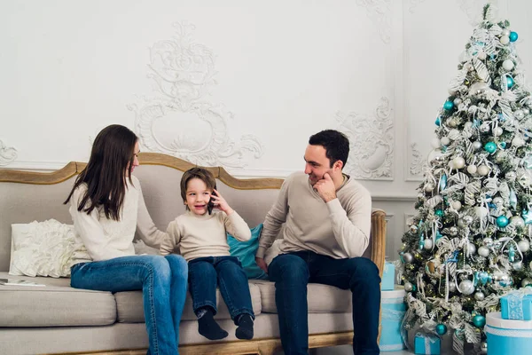 Teléfono de la familia hablando - lindo niño, su madre y padre están sentados en el sofá —  Fotos de Stock