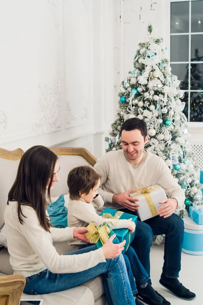 Felicidad, generación, vacaciones y concepto de personas - familia feliz con cajas de regalo sentado en el sofá en casa —  Fotos de Stock
