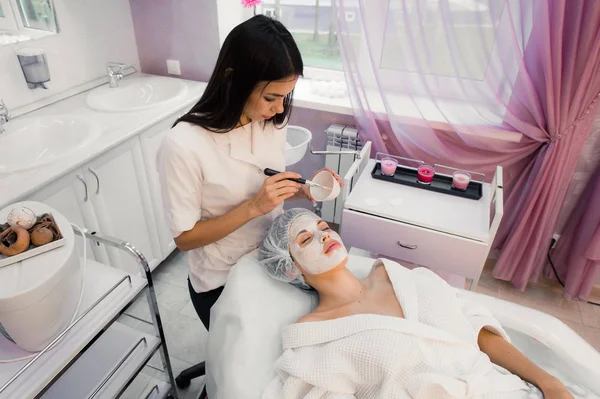 Retrato de mujer joven mientras que el procedimiento cosmético facial en el salón de spa — Foto de Stock