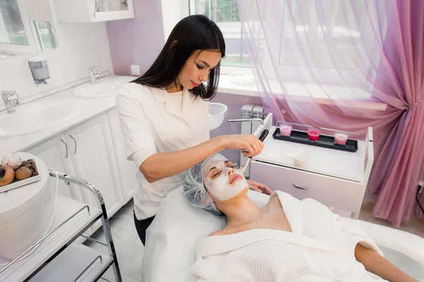 Retrato de mujer joven mientras que el procedimiento cosmético facial en el salón de spa —  Fotos de Stock