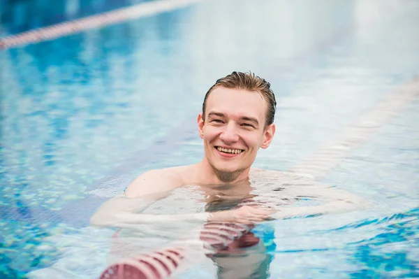 Guapo atlético macho posando en un swinning piscina — Foto de Stock