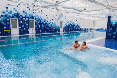 iki genç güzel esmer kız kapalı yüzme havuzunda