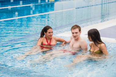 Neşeli arkadaşları yüzme havuzunda rahatlatıcı