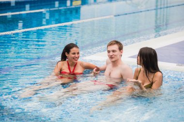 Neşeli arkadaşları yüzme havuzunda rahatlatıcı