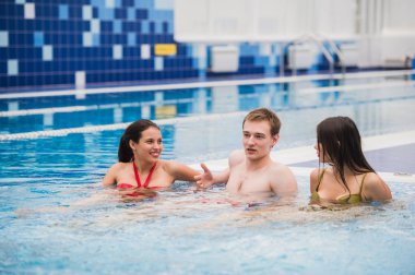 Neşeli arkadaşları yüzme havuzunda rahatlatıcı