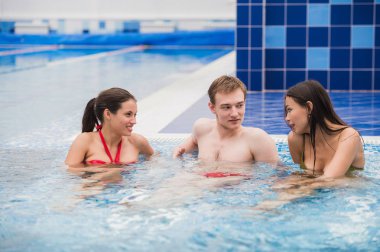 Neşeli arkadaşları yüzme havuzunda rahatlatıcı