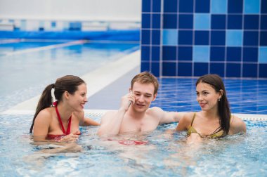 Yüzme Havuzu yapım çağrı cep telefonunda gülümseyen insanlarla. Sağlık, gevşeme ve iletişim kavramı