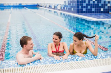 Yüzme havuzunda parti. üç arkadaş kapalı dans