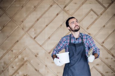 Adam boya ve ahşap duvar arka plan üzerinde ararken fırça kalay ile