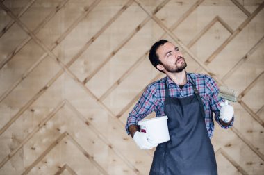 Adam boya ve ahşap duvar arka plan üzerinde ararken fırça kalay ile